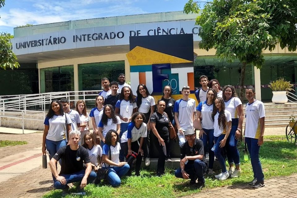 Foto de um grupos de professores e alunos, em pé, em frente a um dos prédios da UFT